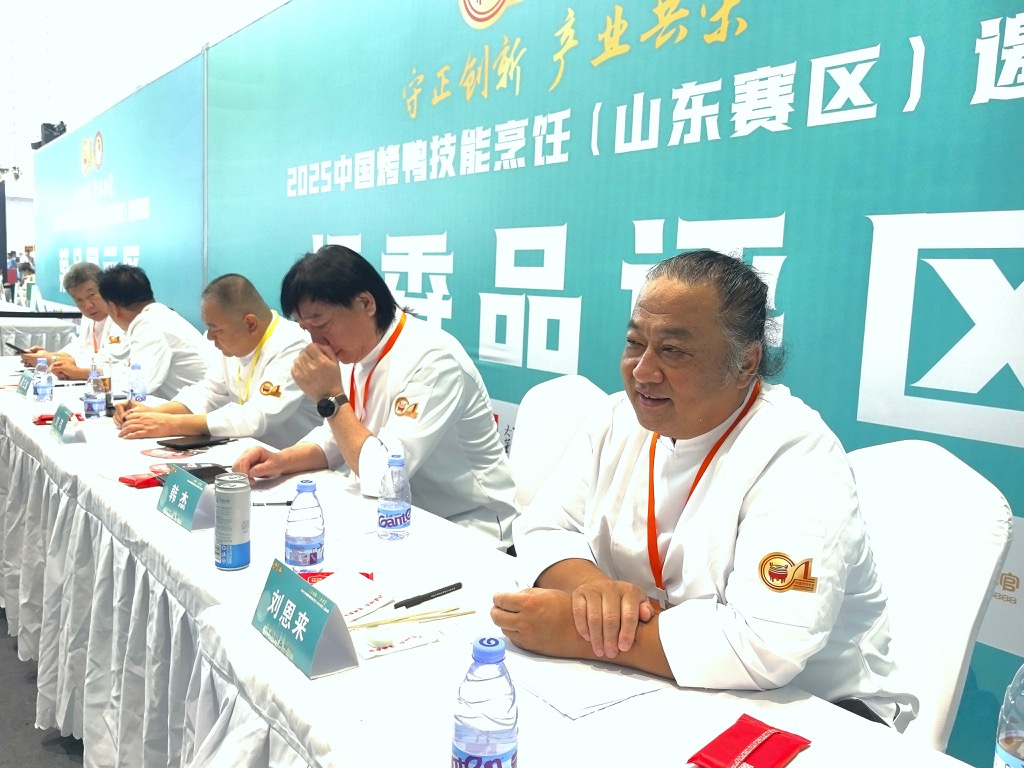 Master Liu seated on a judging panel during a Jinan foodservice ingredients exhibition related activity.